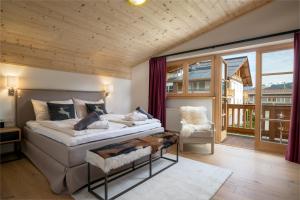 a bedroom with a large bed and a large window at Kirchberg Chalet by Alpine Host Helpers in Kirchberg in Tirol