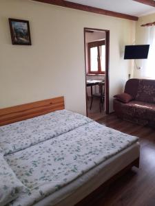 a bedroom with a bed and a couch at Pokoje gościnne Kozica in Zakopane