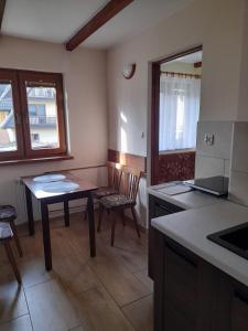 a kitchen with a table and chairs in a room at Pokoje gościnne Kozica in Zakopane