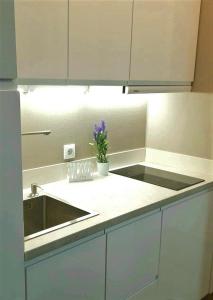 a kitchen counter with a sink and a vase of flowers at Coral Apartment La Cala Beach in La Cala de Mijas
