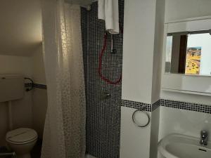 uma casa de banho com um chuveiro, um WC e um lavatório. em Amerigo Casa Vacanza em Cefalù