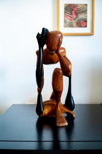 a wooden figurine of two people on a table at Sea View & Sundown, 150m from the Beach and Surf Spots in Costa da Caparica