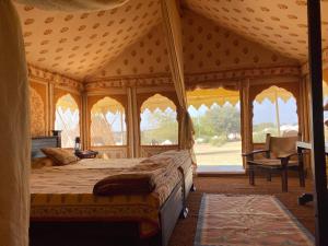 a bedroom with a large bed in a tent at MANVĀR SEVAN, THE DESERT CAMP in Shaitrāwa