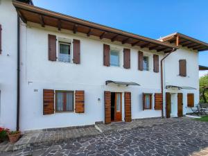 uma casa branca com portas e janelas de madeira em Casa Olivi Calmasino em Calmasino
