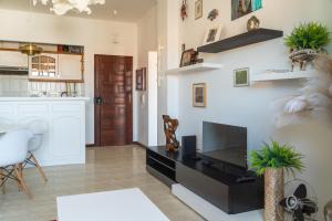 a living room with a flat screen tv on a wall at Sea View & Sundown, 150m from the Beach and Surf Spots in Costa da Caparica