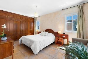 a bedroom with a large white bed and a couch at Villa Golf del Sur in San Miguel de Abona