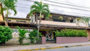 a building with palm trees in front of it at Hostal La Buena Onda in Matagalpa