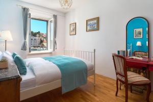 1 dormitorio con cama, escritorio y ventana en Sun Spalato Fara, en Hvar