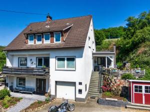 a white house with a motorcycle parked in front of it at Mondscheinquelle in Lennestadt