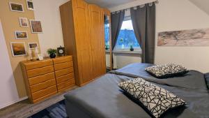 a bedroom with two beds and a dresser and a window at Mondscheinquelle in Lennestadt