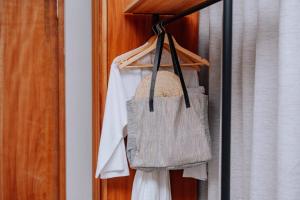 a closet with white shirts and a bag at Samawa Living in Paje