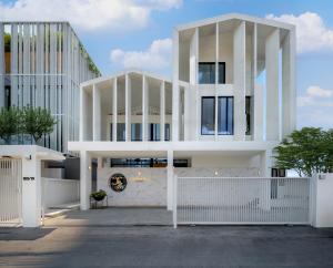 a white building with a white fence in front of it at 曼谷市中心素坤逸城中大宅豪华泳池河畔别墅 in Bangkok