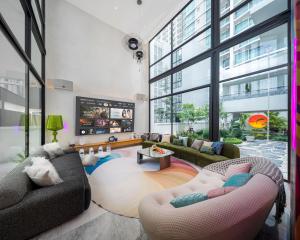 a living room with two couches and a large window at 曼谷市中心素坤逸城中大宅豪华泳池河畔别墅 in Bangkok