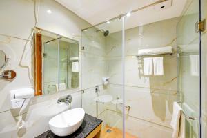 a bathroom with a shower and a toilet and a sink at Classio Royale By IO Hotels in Amritsar