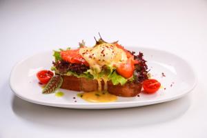 a plate of food with an egg on a sandwich at Royal Palace Luxury Hotel and SPA in Khmelʼnytsʼkyy