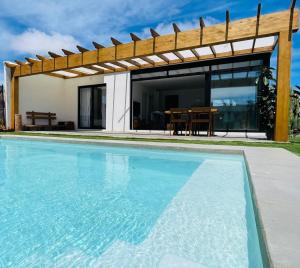 a swimming pool in front of a house at Bungalow + Piscina independiente in La Oliva