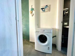 Waschmaschine und Trockner in einem kleinen Zimmer in der Unterkunft Be Your Home - Casa Vetulonia in Santa Marinella