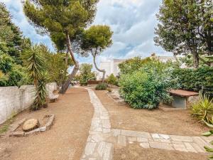 einen Pfad in einem Garten mit Bäumen und Sträuchern in der Unterkunft Be Your Home - Casa Vetulonia in Santa Marinella