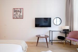 a room with a bed and a tv and a chair at THE GOOD FLATS in Brussels
