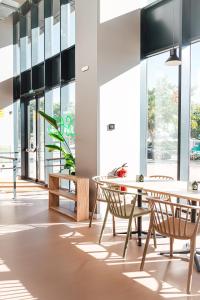 a room with tables and chairs and windows at Atenea Living in Mataró