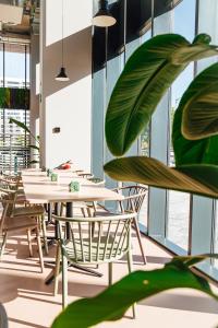 a row of tables and chairs in a room with windows at Atenea Living in Mataró
