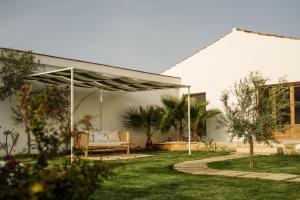 un jardín con un sofá bajo una pérgola en Amagatay Menorca en Alaior