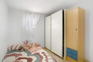 a bedroom with a bed and a cabinet at Atico vecindario, aeropuerto in Cruce de Arinaga