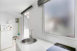 a bathroom with a sink and a window at Atico vecindario, aeropuerto in Cruce de Arinaga +17 photos