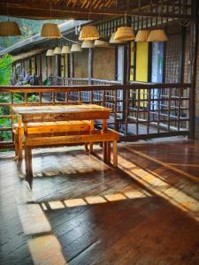 a wooden table and bench in a building at Lokal Hut Bed and Breakfast in Puerto Princesa City