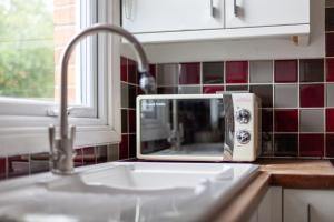 a microwave sitting on a kitchen counter next to a sink at The Harlesden Villas in London