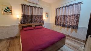 加尔各答Laxmi Niwas, Salt Lake, Kolkata, 10mins from Sector 5的一间卧室设有红色的床和2个窗户