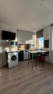 a kitchen with a washing machine and a table with chairs at Your Cozy Family-Friendly Flat in Vibrant Riga in Riga