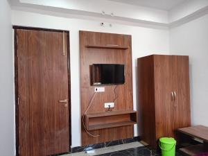 een kamer met houten kasten en een flatscreen-tv bij DAYA RESORT in Ayodhya