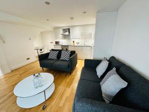 a living room with a couch and a table at West Street Mews - Serviced Accommodation in Exeter