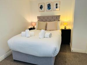 a bedroom with a large white bed with three pillows at West Street Mews - Serviced Accommodation in Exeter