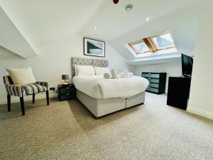 a bedroom with a bed and a chair at West Street Mews - Serviced Accommodation in Exeter