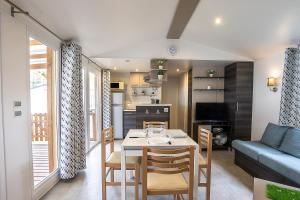 uma cozinha e sala de estar com mesa e cadeiras em Mobilhome au bois masson em Saint-Jean-de-Monts