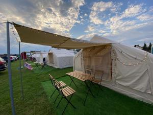 une tente avec des chaises et une table en face de celle-ci dans l'établissement Mara Camping Mobile Homes, à Liptovský Trnovec