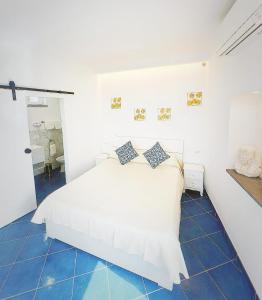 a bedroom with a white bed and blue tile floors at Vista Mare BB in Anacapri