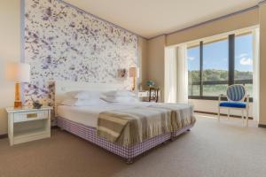 a bedroom with a bed and a floral wall at Pestana Bahia Praia Nature & Beach Resort in Vila Franca do Campo