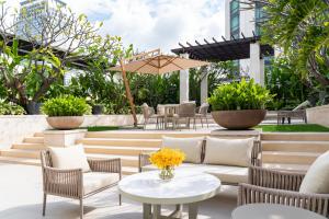 a patio with chairs and tables and an umbrella at Siam Kempinski Hotel Bangkok - SHA Extra Plus Certified in Bangkok