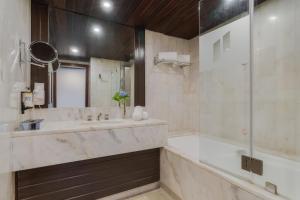 a bathroom with a tub and a sink and a shower at Pestana Bahia Praia Nature & Beach Resort in Vila Franca do Campo