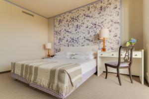 a bedroom with a bed and a desk with a chair at Pestana Bahia Praia Nature & Beach Resort in Vila Franca do Campo