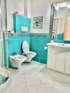 Baño azul con aseo y lavamanos en Sea View Apartment, en Cardedu