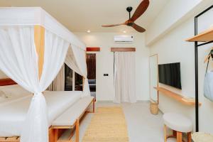 a bedroom with a bed and a ceiling fan at Samawa Living in Paje