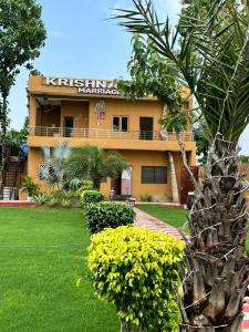 Krishna Vatika Hotel في Shivāpur: مبنى اصفر عليه لافته