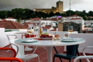 a white table with a bowl of fruit and wine glasses at Porta da Arrábida Suites in Palmela