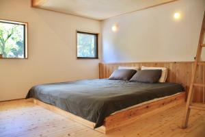 a bedroom with a bed and two windows at まるしっぽ邸-Marushippotei-連泊20パーセントOFF!Onsen,BBQ,hammock,national park,home theater in Murautsuri