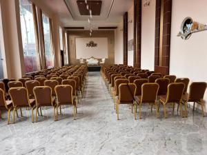 a large room with a row of chairs and a stage at Krishna Vatika Hotel in Shivāpur