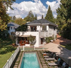 a house with a swimming pool in front of a house at Hyde Park Guest House in Johannesburg